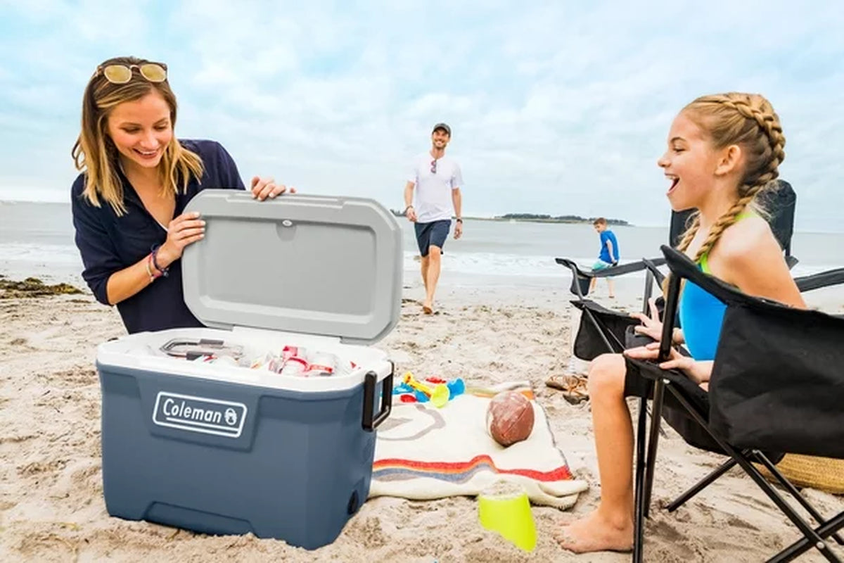 A mother looking into a cooler for a soda to give it to her daughter